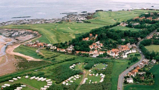 aerial photo of north Belhaven showing the old village, the bridge over the Biel Water at low tide in the John Muir Park, and the John Muir Clifftop Trail to Dunbar round Winterfield golf course. Photo by Skyviews on a Saturday in June 2002